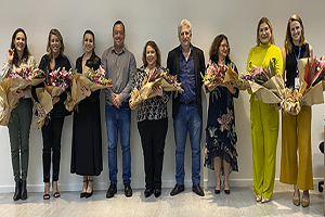 Imagem com nove pessoas, sendo sete mulher com um buque de flores coloridas nas mãos